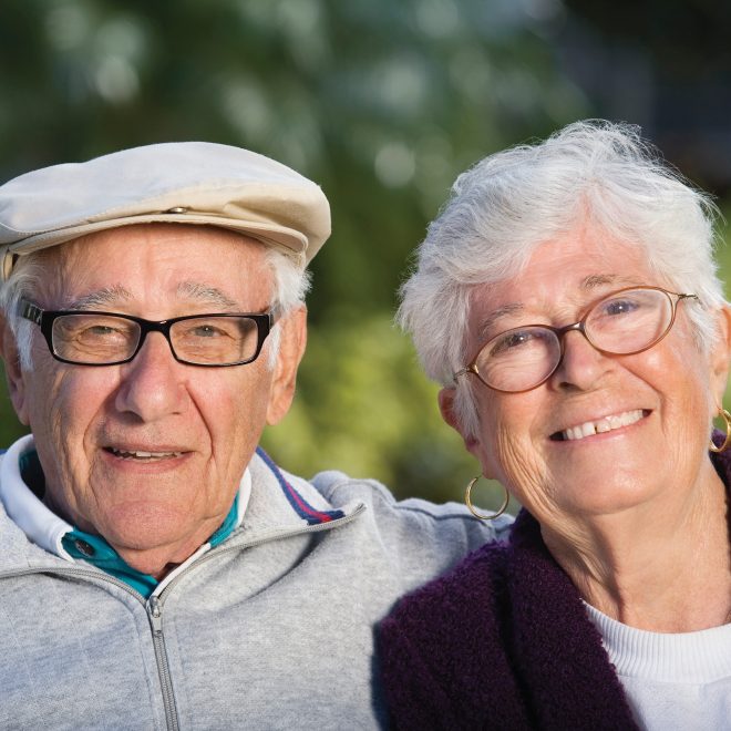 Senior couple sitting on a bench and smiling