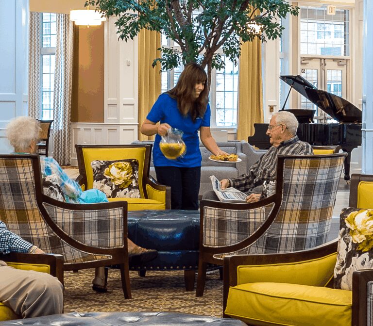 Staff serving residents water in the common lounge area