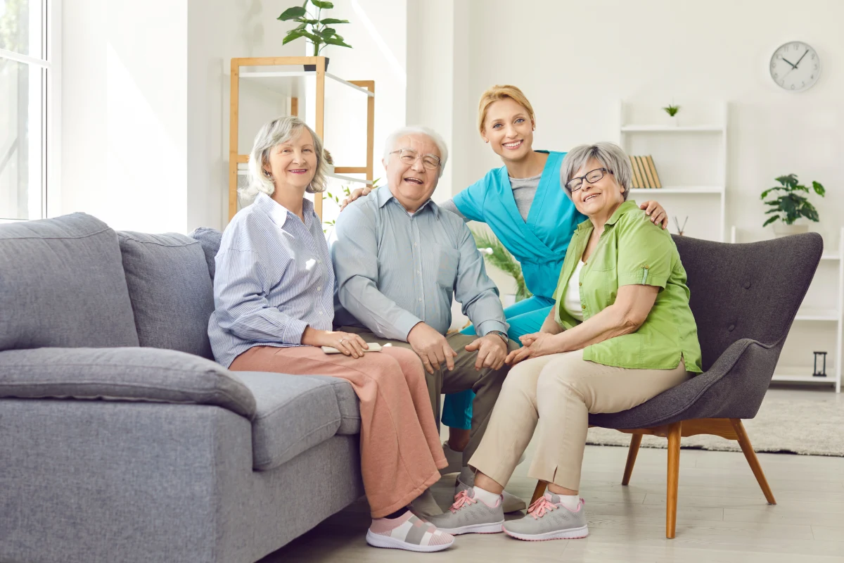 Group of seniors sitting with team member and smiling